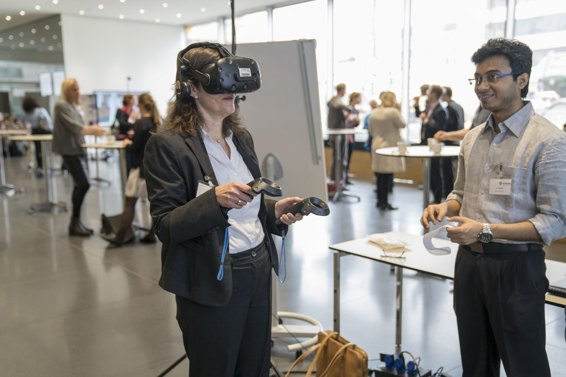 Eine Frau mit VR-Brille und ein Mann stehend am Stand des VR-Exponats