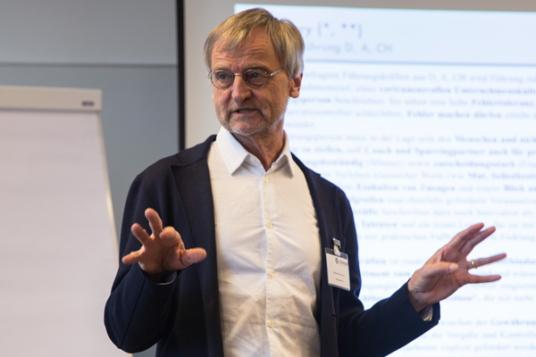Wolfgang Zimmermann spricht stehend vor den Workshopteilnehmer_innen